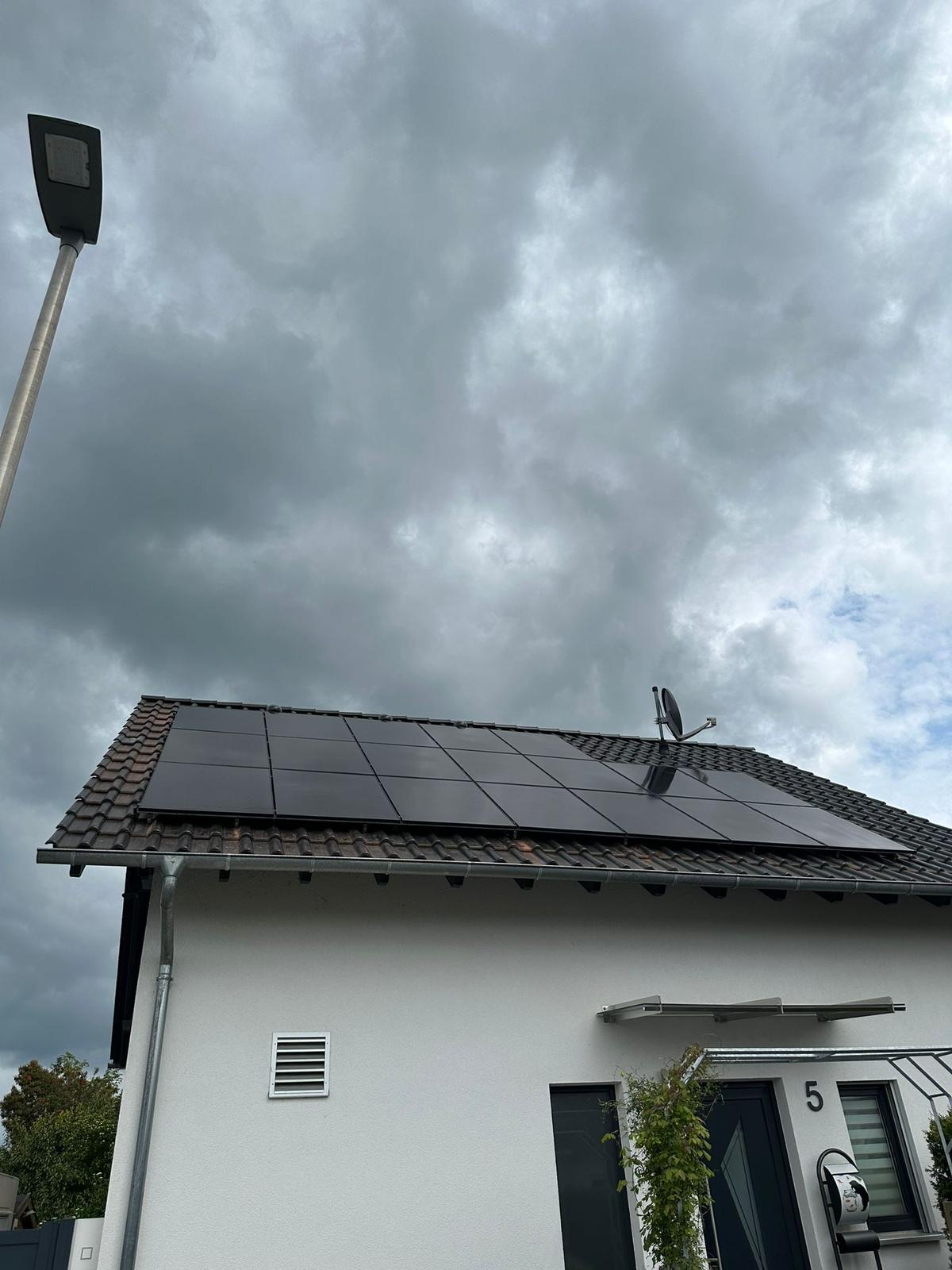 Schwarze Photovoltaik-Module auf dem Satteldach eines Einfamilienhauses